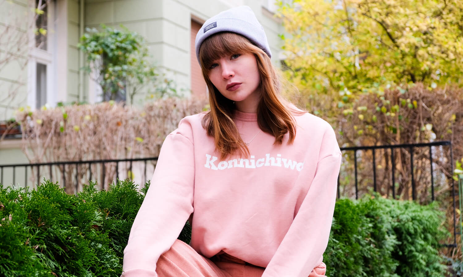 Frau trägt rosa Sweater und graue Mütze